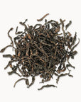 Timebai da hong pao oolong tea loose leaves piled on a white background.
