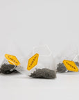 Biodegradable PLA pyramid tea bags with whole-leaf Bi Luo Chun green tea and orchid essence.