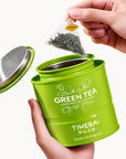 Timebai Orchid Bi Luo Chun Green Tea – Hand Lifting a Pyramid Tea Bag from an Open Tin
