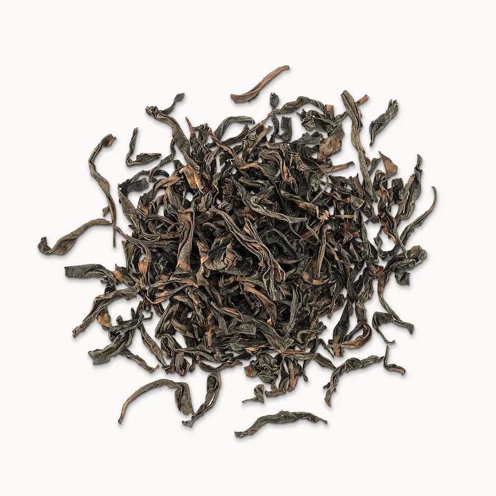 Timebai da hong pao oolong tea loose leaves piled on a white background.