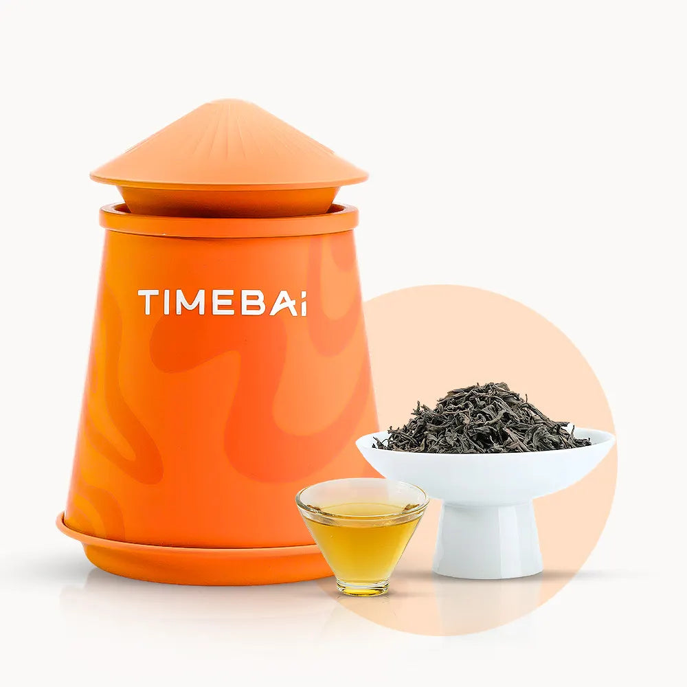 Timebai da hong pao oolong tea with an orange tea canister, loose leaves in a white bowl, and a glass cup of golden tea on a white background.