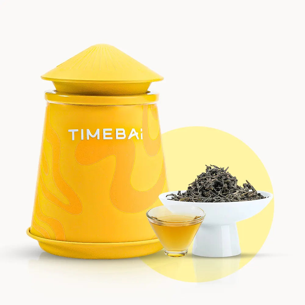 Timebai gardenia dancong oolong tea with a yellow tea canister, loose leaves in a white bowl, and a glass cup of golden tea on a white background.