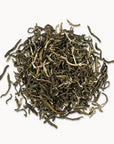 Timebai jasmine mao jian green tea loose leaves piled on a white background.