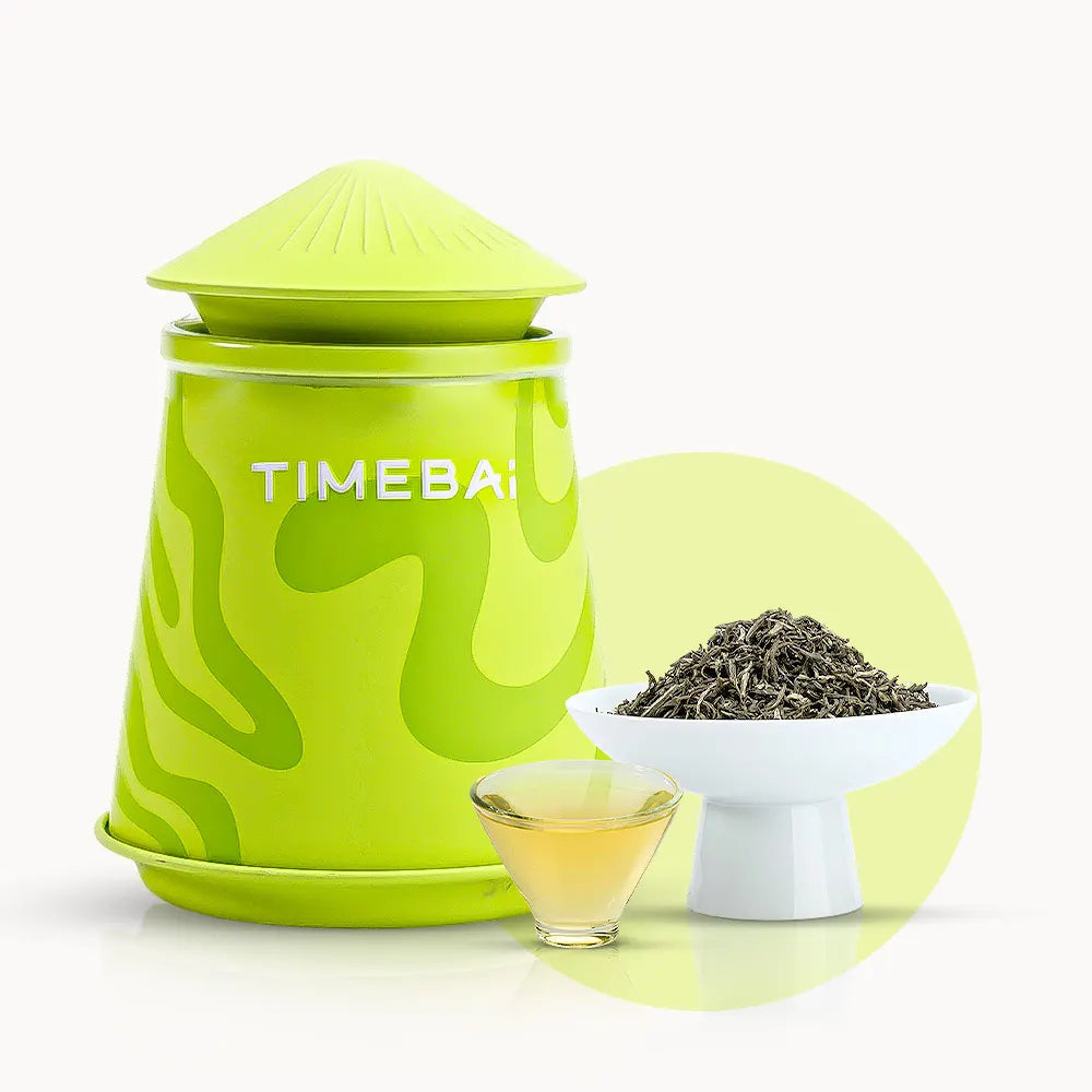Timebai jasmine mao jian green tea with a lime green tea canister, loose leaves in a white bowl, and a glass cup of pale yellow tea on a white background.
