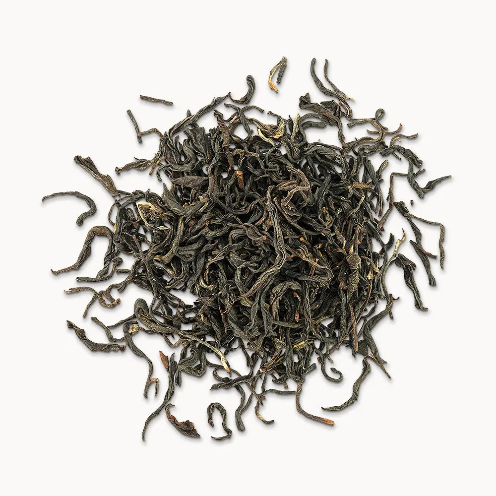 Timebai_yunnan_beauty_black_tea_loose_leaves_piled_on_a_white_background.