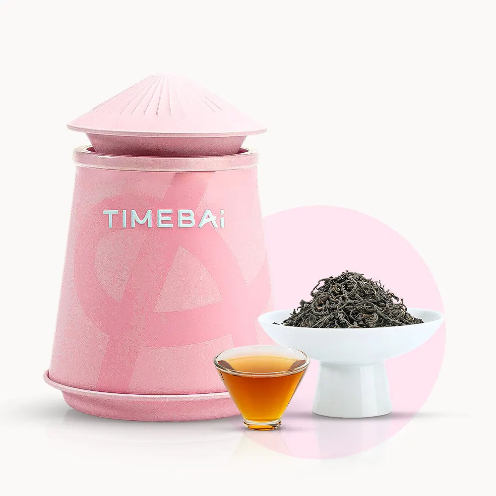 Timebai_yunnan_beauty_black_tea_with_a_pink_tea_canister_loose_leaves_in_a_white_bowl_and_a_glass_cup_of_amber_tea_on_a_white_background.