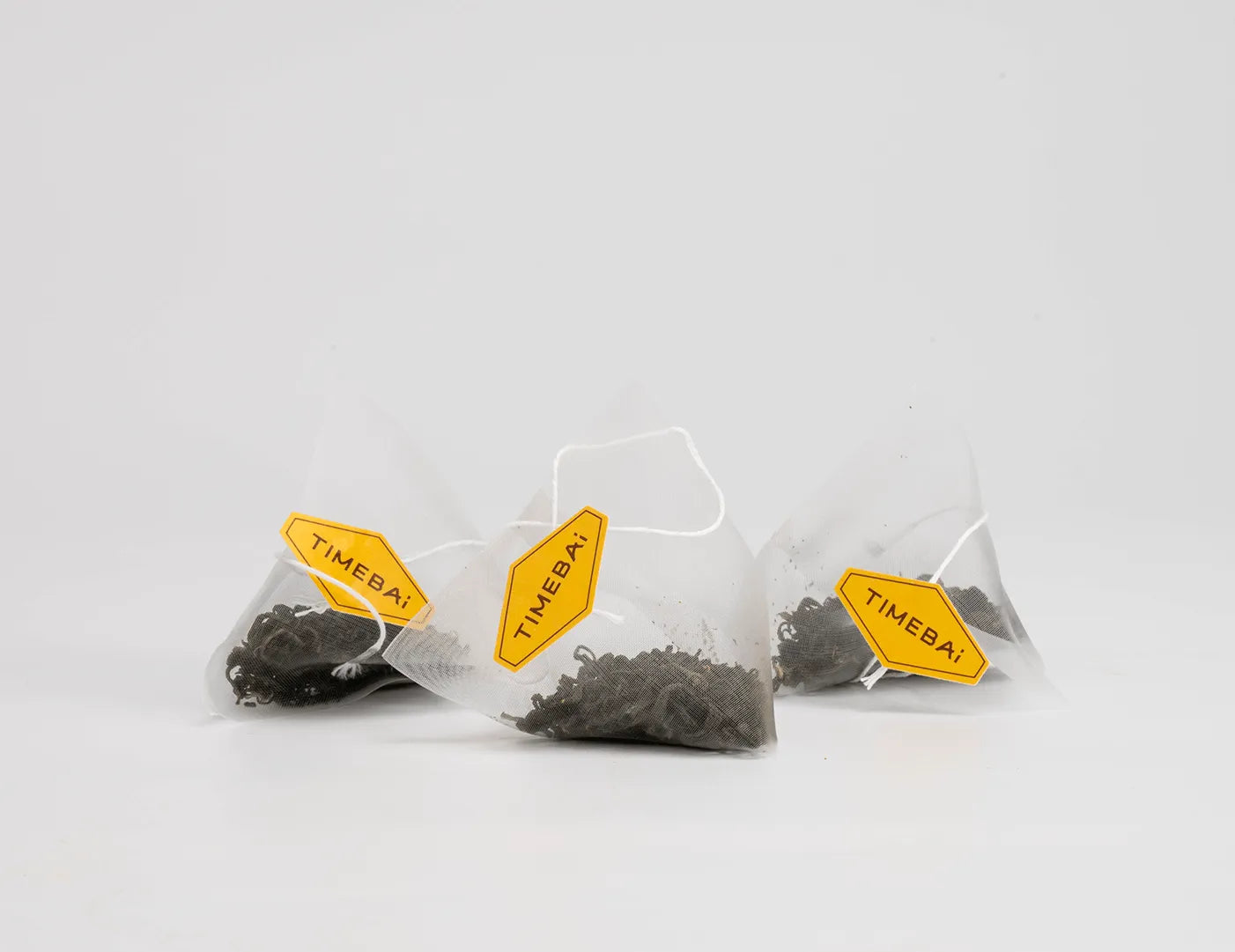 Biodegradable PLA pyramid tea bags with whole-leaf Bi Luo Chun green tea and orchid essence.