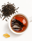 Timebai Ceylon Black Tea Brewing in a White Cup Beside Loose Tea Leaves